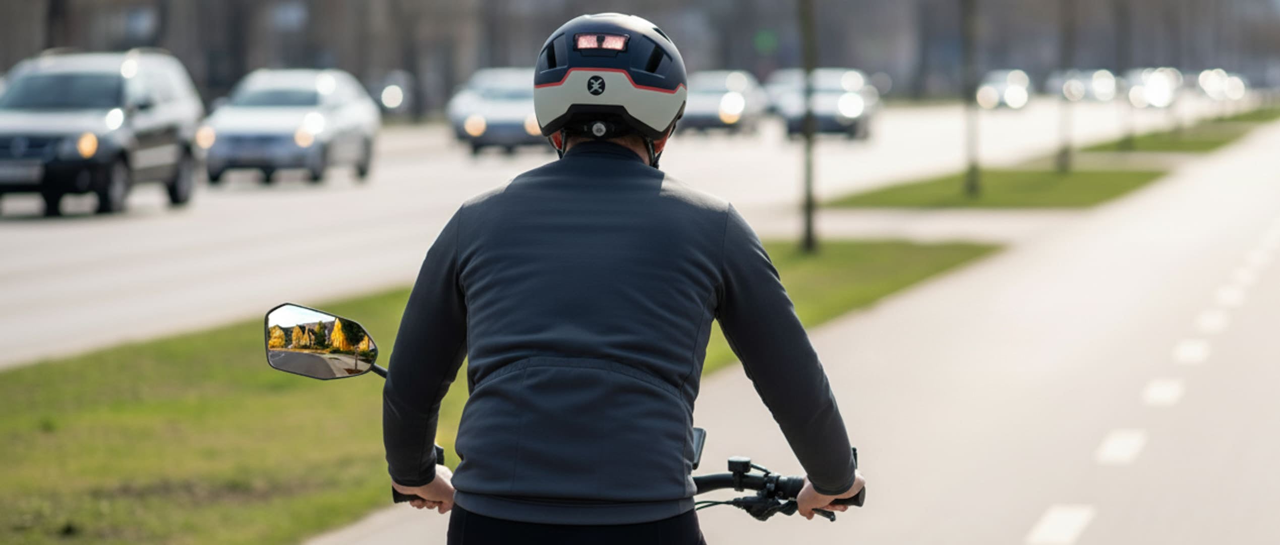 Cyclist with rearview mirrors riding in traffic for safer awareness