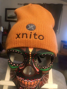 Orange Xnito beanie on decorative mask